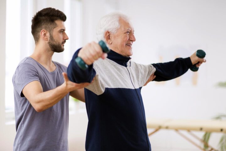 A senior lifting weights in physiotherapy after a stroke